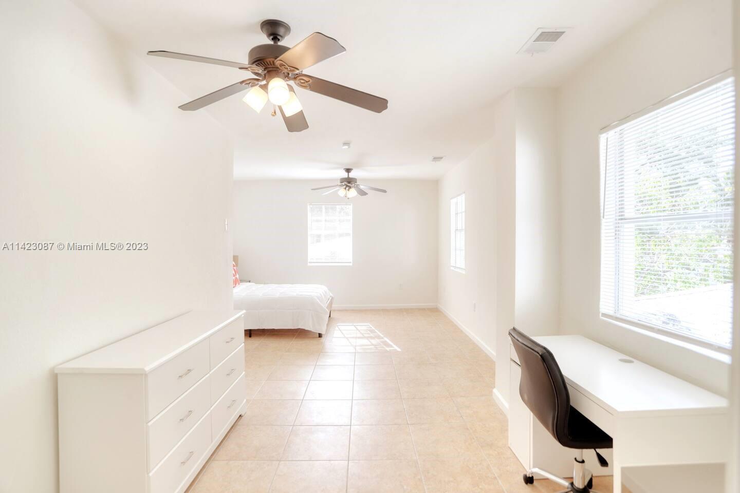 3628 Thomas Avenue Miami, FL 33133 - Photo 11 of 24 a bedroom with a bed and a chandelier