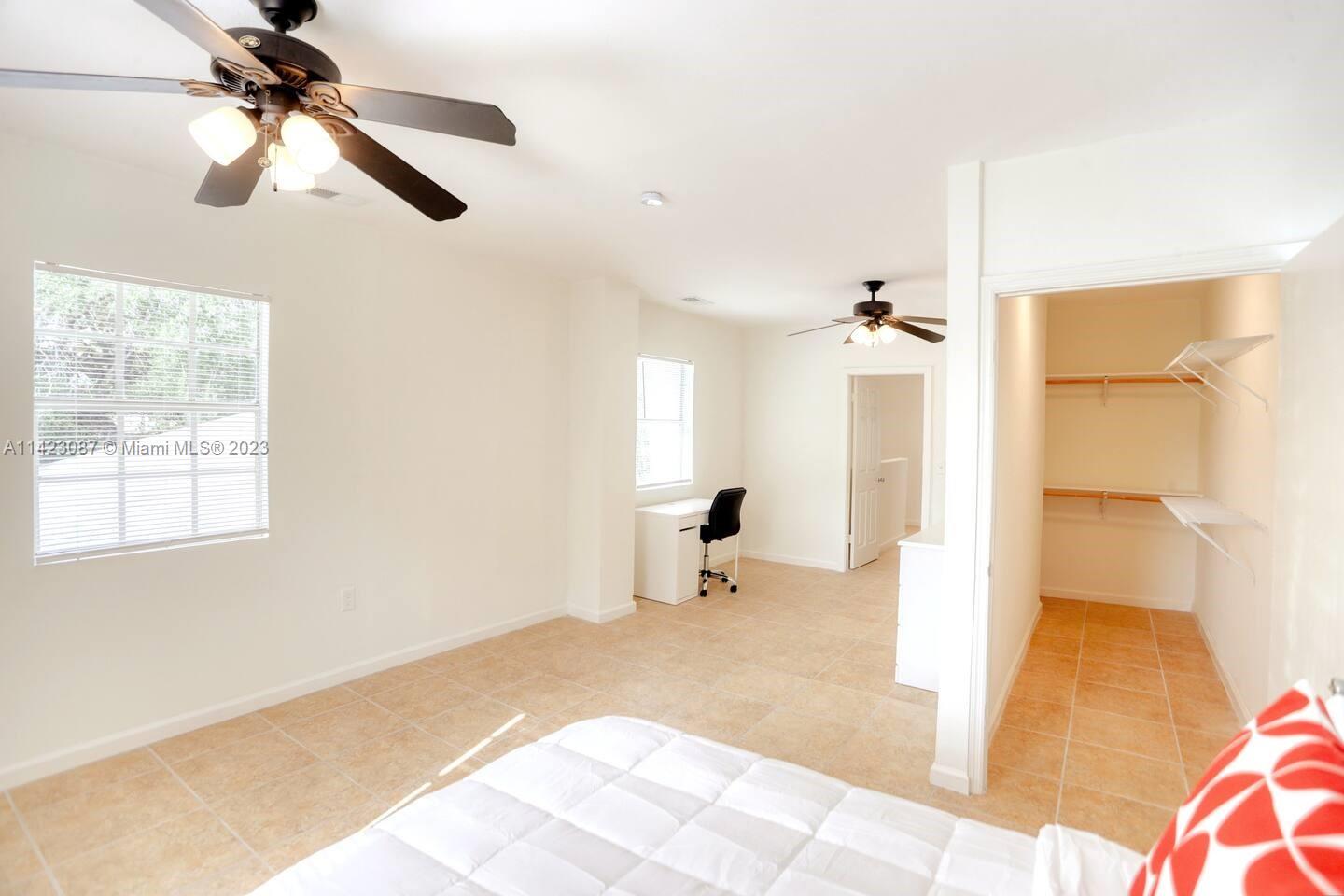 3628 Thomas Avenue Miami, FL 33133 - Photo 13 of 24 a bedroom with a bed and a chandelier