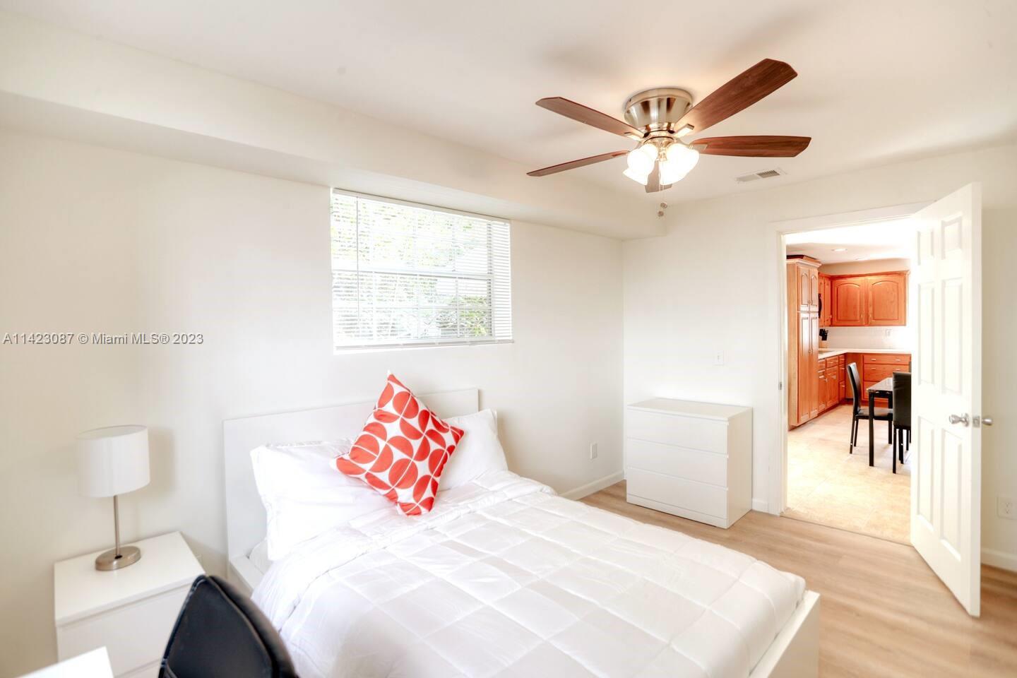 3628 Thomas Avenue Miami, FL 33133 - Photo 14 of 24 a bedroom with a bed and a chandelier