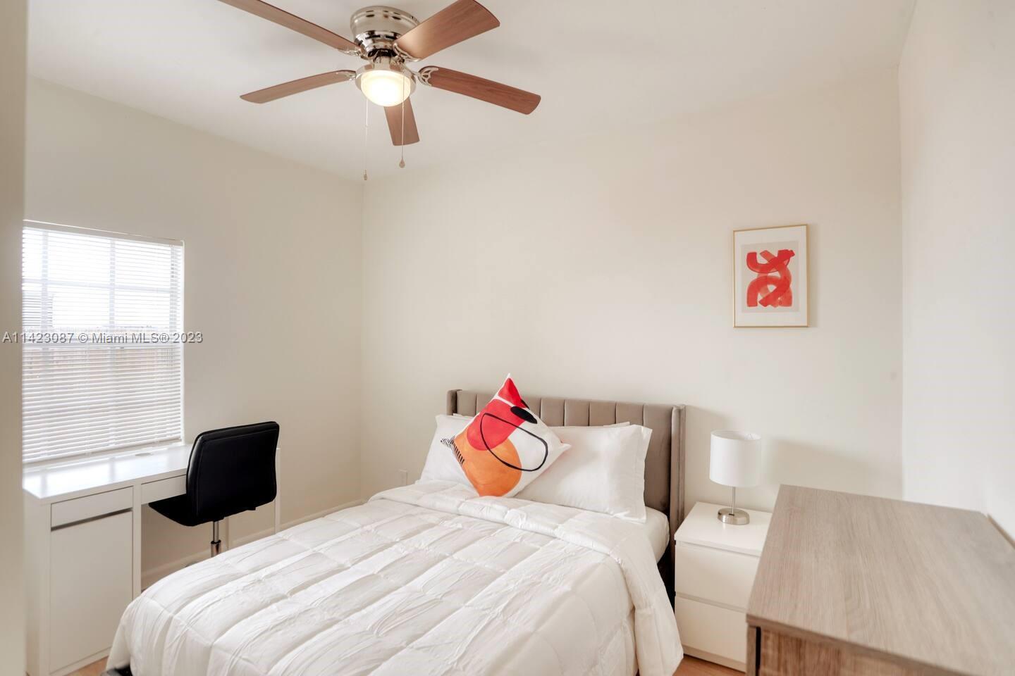 3628 Thomas Avenue Miami, FL 33133 - Photo 17 of 24 a bedroom with a bed and a chandelier