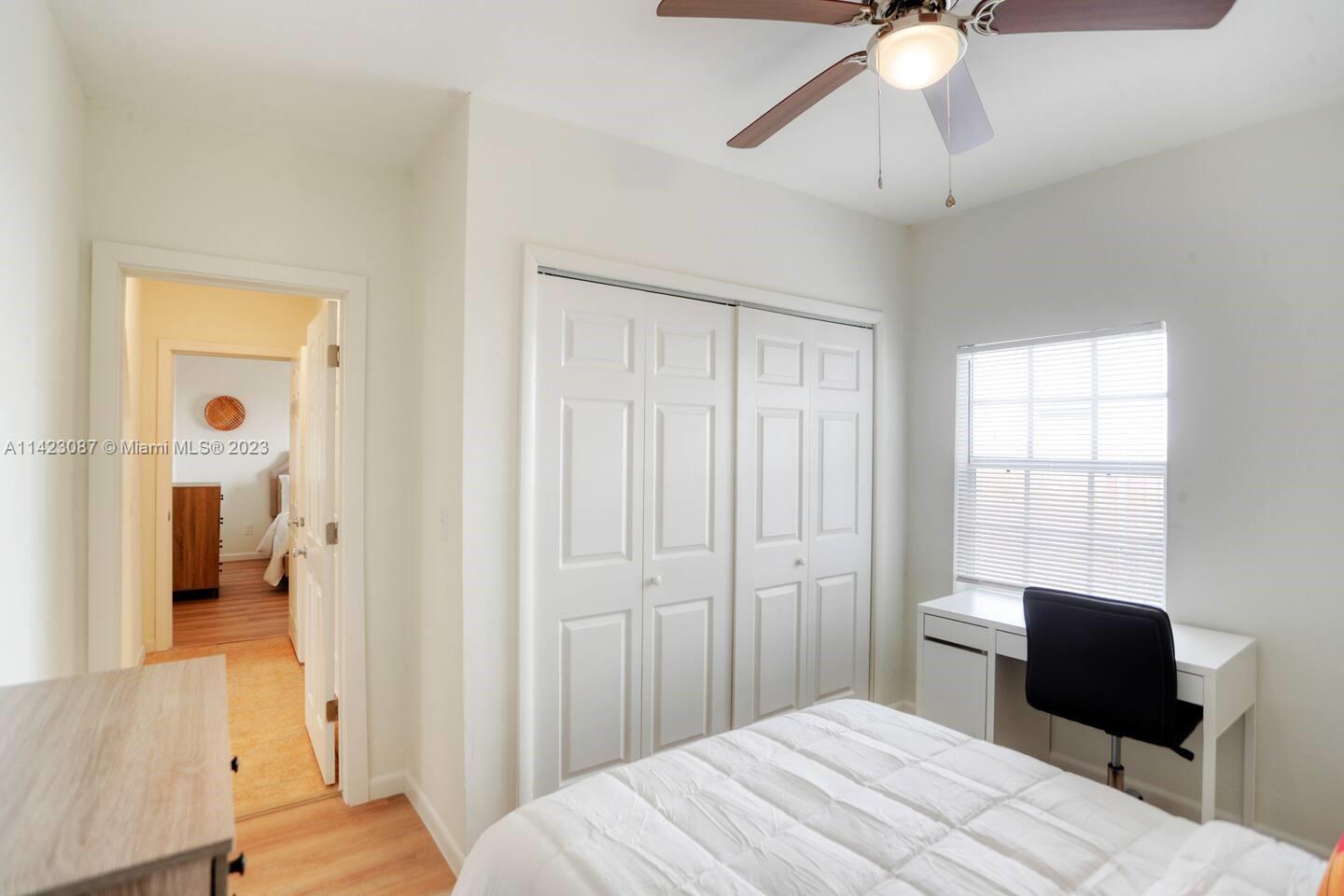 3628 Thomas Avenue Miami, FL 33133 - Photo 19 of 24 a bedroom with a bed and a chandelier