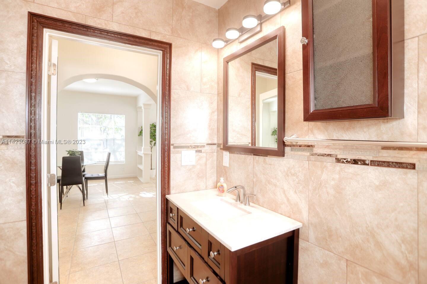3628 Thomas Avenue Miami, FL 33133 - Photo 21 of 24 a bathroom with a sink and a mirror