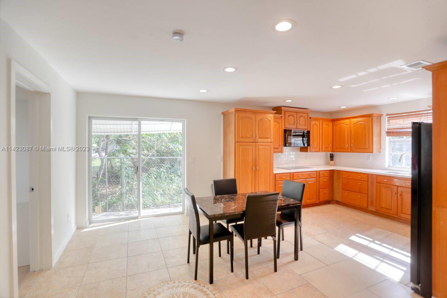 3628 Thomas Avenue Miami, FL 33133 - Photo 6 of 24 a dining area with furniture and a large window