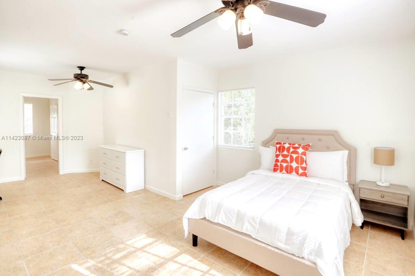 3628 Thomas Avenue Miami, FL 33133 - Photo 10 of 24 a bedroom with a bed and a chandelier