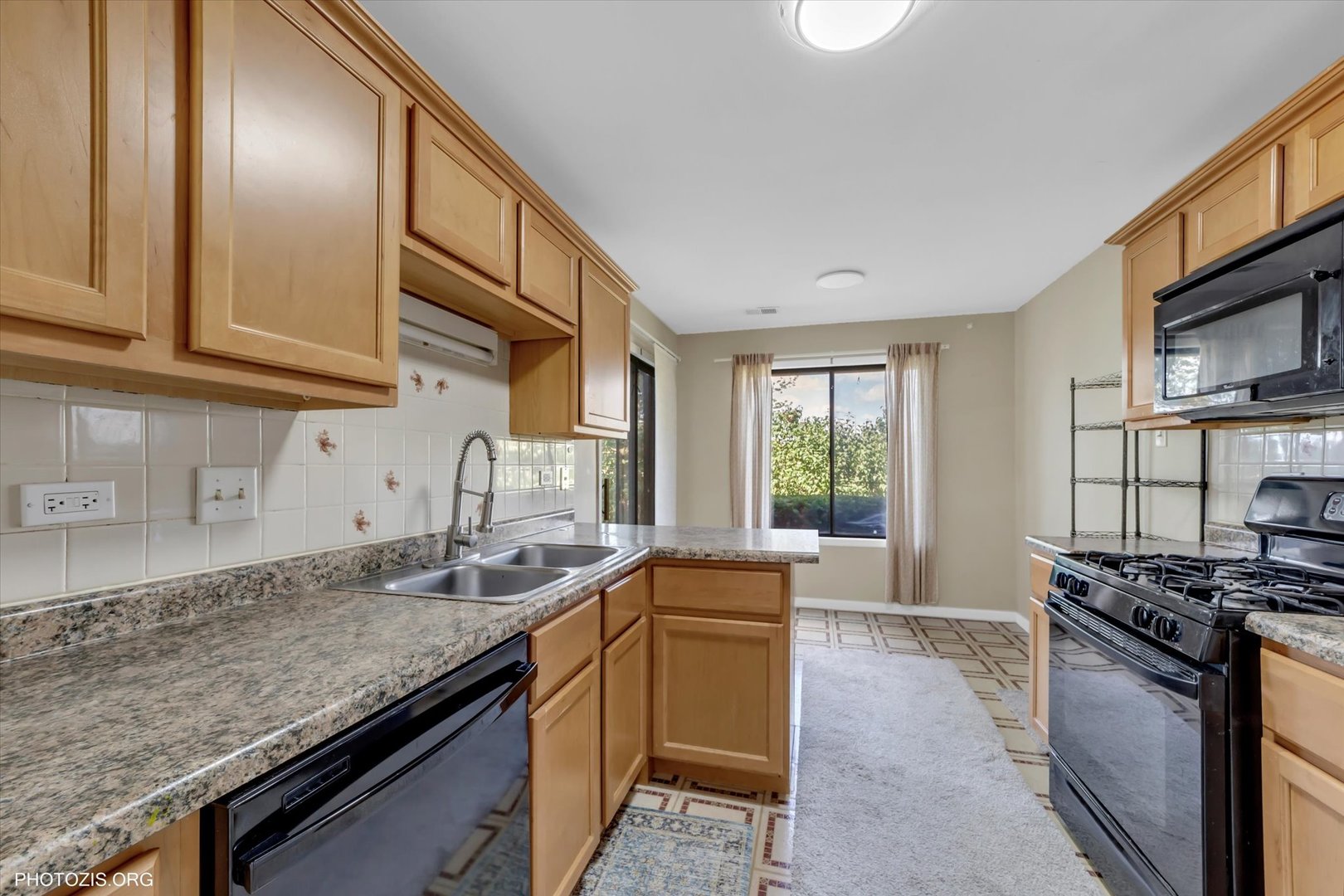 918 East Kings Row, Unit 1 Palatine, IL 60074 - Photo 9 of 23 a kitchen with stainless steel appliances granite countertop a sink stove and cabinets