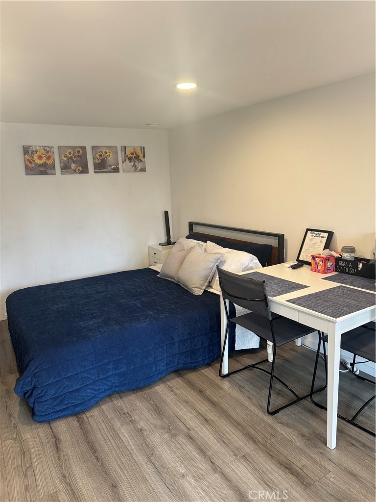 774 Stephens Avenue Fullerton, CA 92833 - Photo 2 of 9 a bed sitting in a bedroom next to a dining table with wooden floor