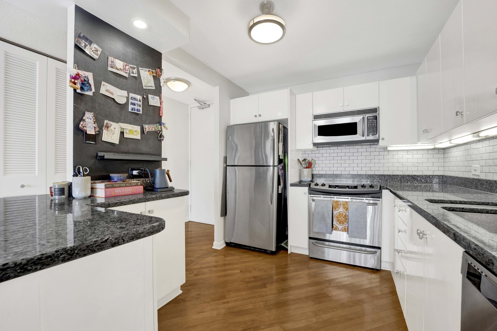 405 North Wabash Avenue, Unit 2614 Chicago, IL 60611 - Photo 9 of 22 a kitchen with stainless steel appliances granite countertop a refrigerator a stove and a sink with wooden floor