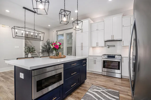 a kitchen with a sink dishwasher a stove and a refrigerator with wooden floor