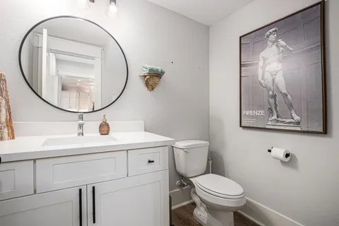 a bathroom with a toilet sink and mirror