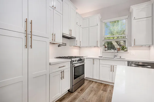 a kitchen with white cabinets and white appliances