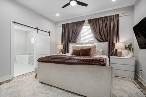 a bedroom with a bed and a flat screen tv