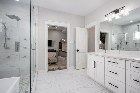 a spacious bathroom with a granite countertop sink mirror and shower
