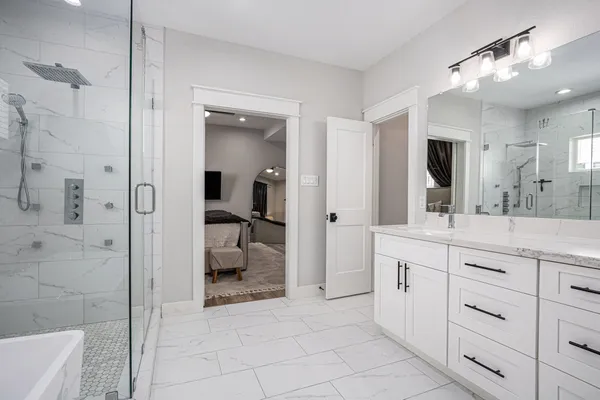 a spacious bathroom with a granite countertop sink mirror and shower