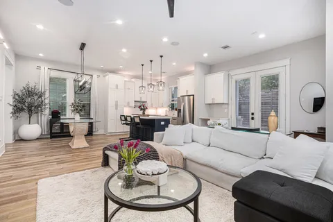 a living room with furniture kitchen and a chandelier