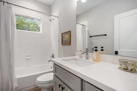 a bathroom with a granite countertop sink toilet and shower