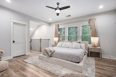 a bedroom with a large bed chandelier and a window