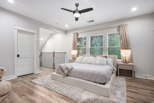 a bedroom with a large bed chandelier and a window