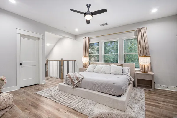 a bedroom with a large bed chandelier and a window