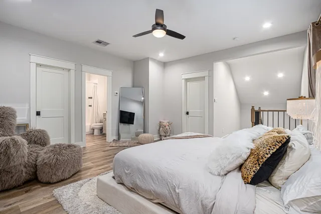 a spacious bedroom with a bed and a chandelier