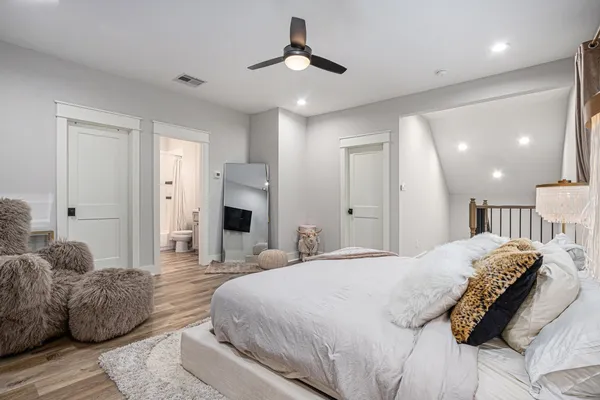 a spacious bedroom with a bed and a chandelier