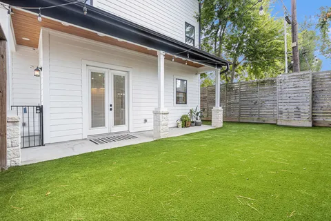 a view of a backyard with plants and large tree