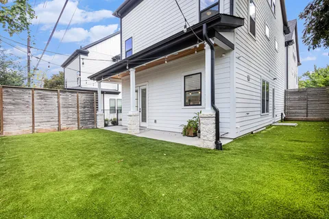 a view of a backyard with plants and large tree