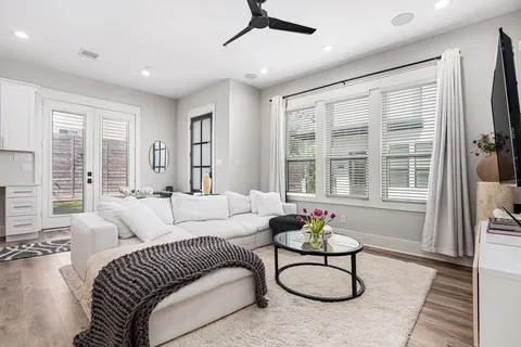a living room with furniture a floor to ceiling window and couch