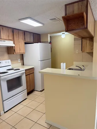 a kitchen with a refrigerator sink stove and cabinets