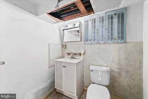 a bathroom with a sink a toilet and a mirror