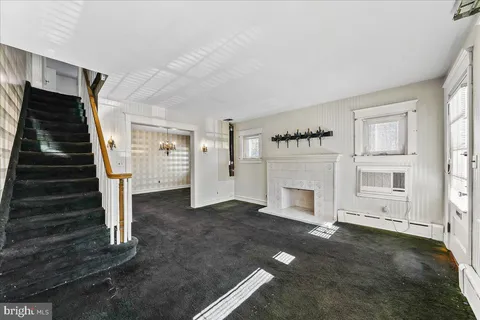 a view of a livingroom with a fireplace stairs and windows