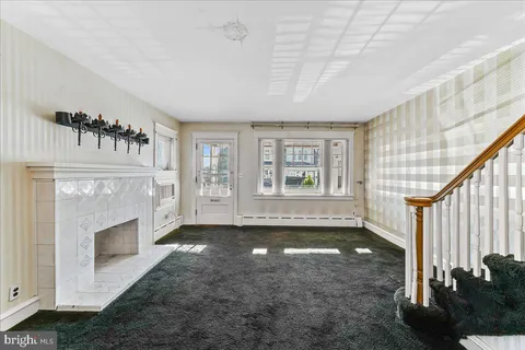 a view of an empty room with a fireplace and a window