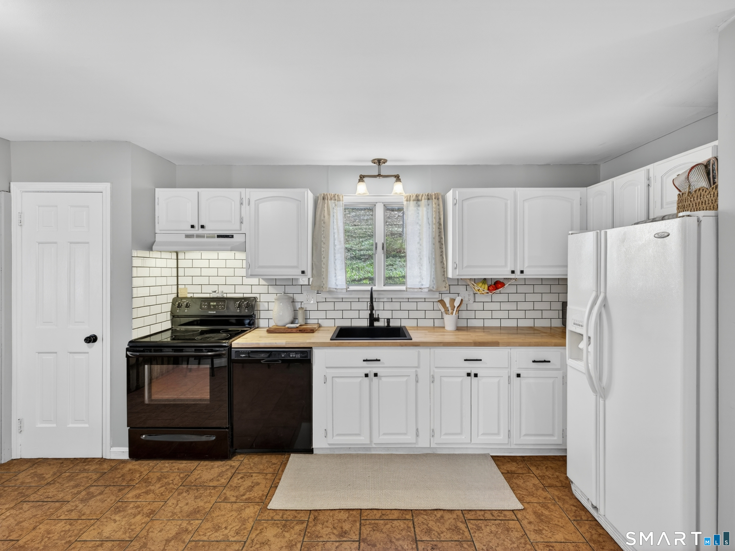 599 Durham Road Guilford, CT 06437 - Photo 11 of 42 a kitchen with granite countertop white cabinets and refrigerator