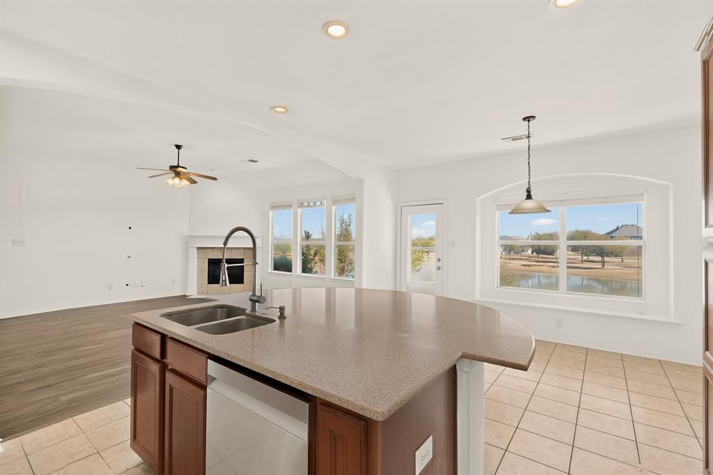14908 Riverside Drive Little Elm, TX 75068 - Photo 14 of 40 Spacious kitchen island with a double basin sink, solid surface countertop, and wood cabinetry
