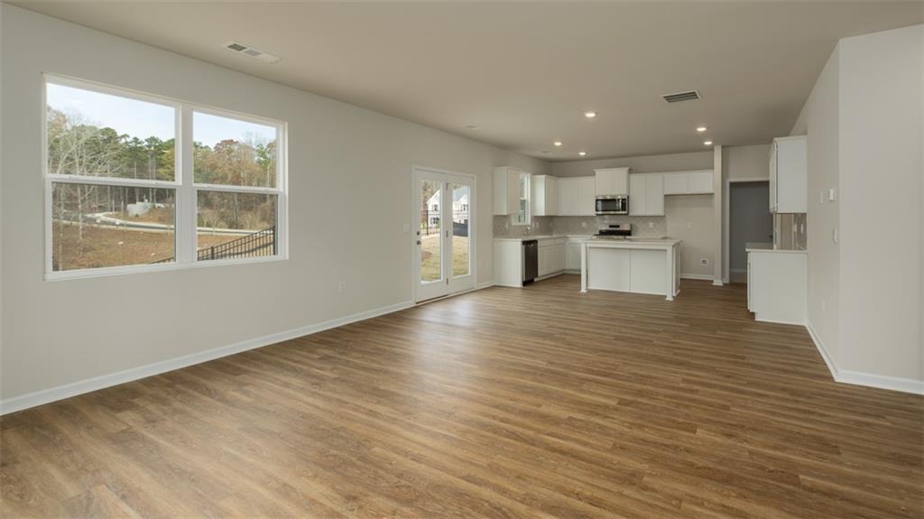 2291 Edgecombe Lane Dacula, GA 30019 - Photo 11 of 42 a view of a kitchen with kitchen island a counter top space a sink wooden floor and a large window