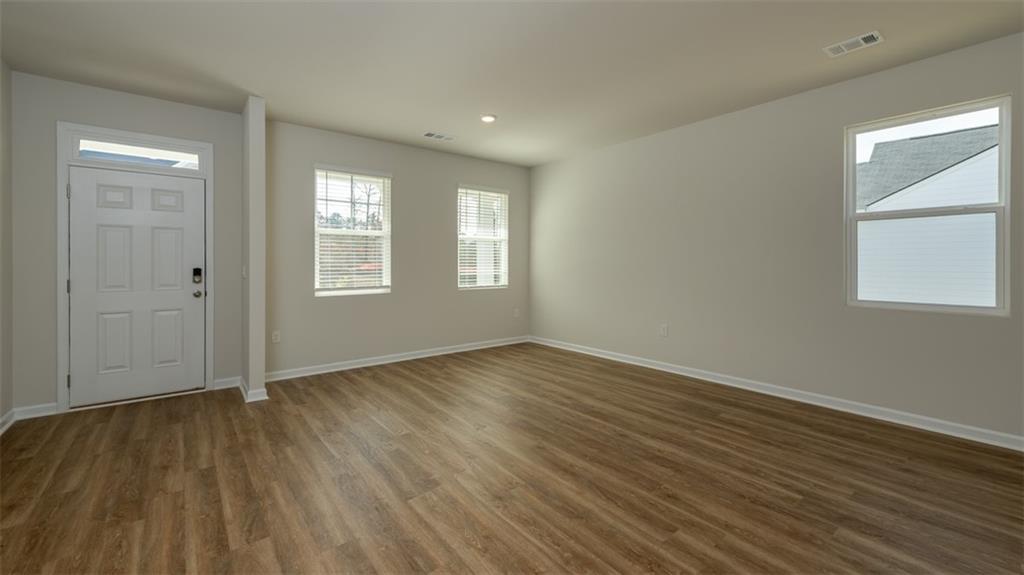 2291 Edgecombe Lane Dacula, GA 30019 - Photo 13 of 42 an empty room with wooden floor and windows