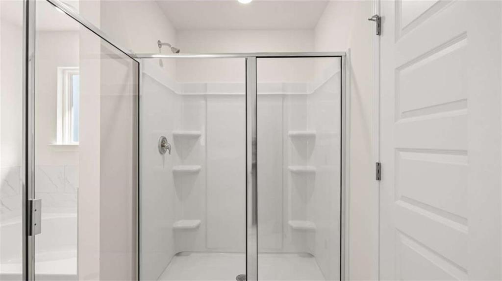 2291 Edgecombe Lane Dacula, GA 30019 - Photo 21 of 42 a bathroom with a glass shower door