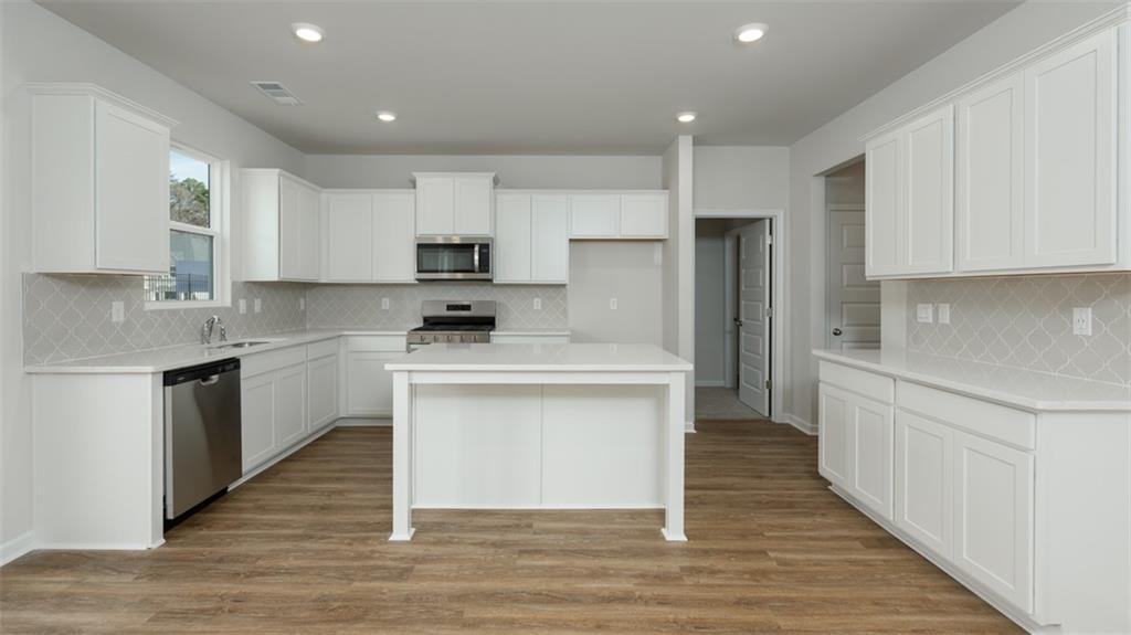 2291 Edgecombe Lane Dacula, GA 30019 - Photo 8 of 42 a kitchen with white cabinets stainless steel appliances and sink