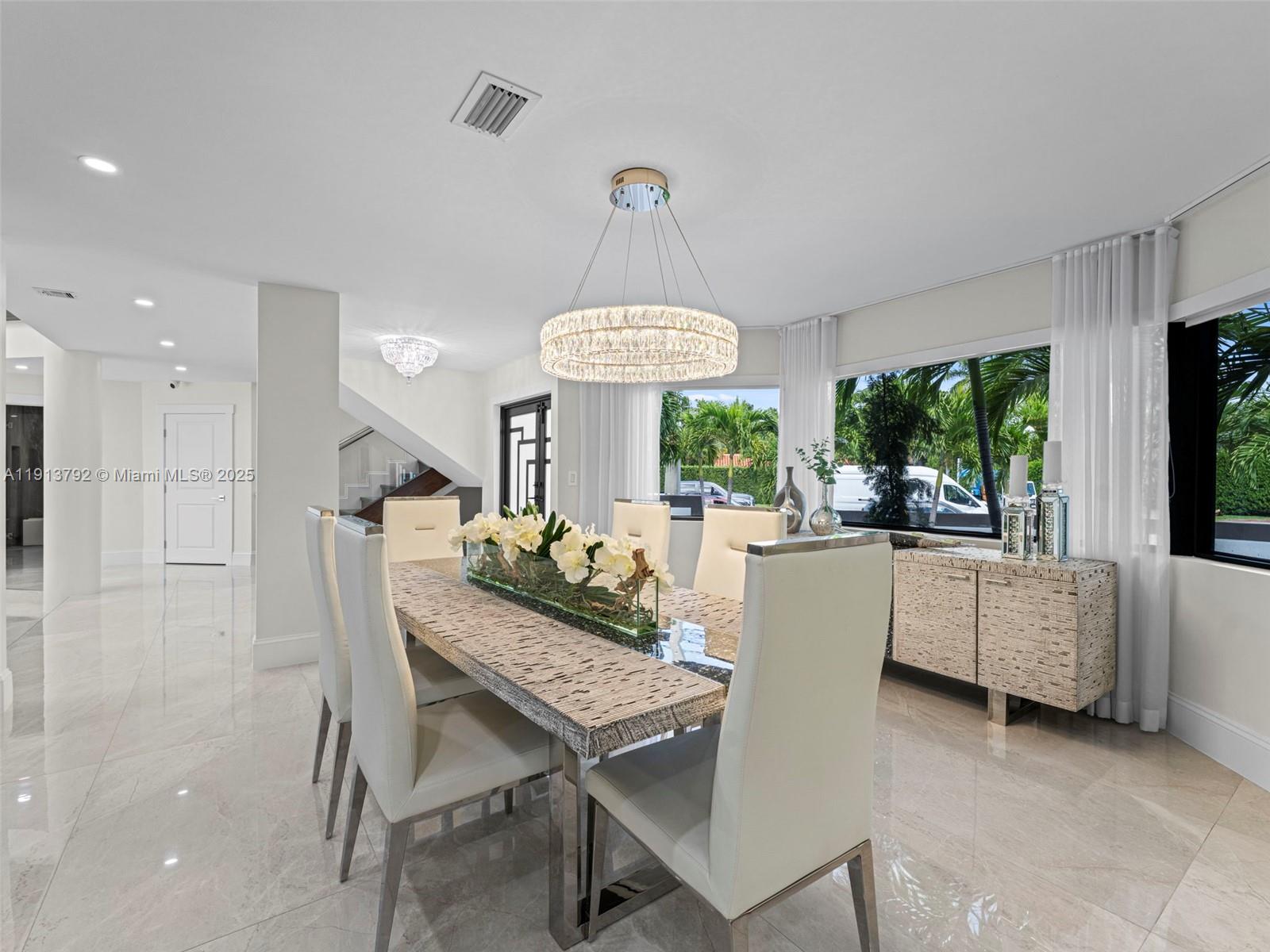 6180 Pine Tree Drive Miami Beach, FL 33140 - Photo 17 of 100 a dining room with furniture a chandelier and window