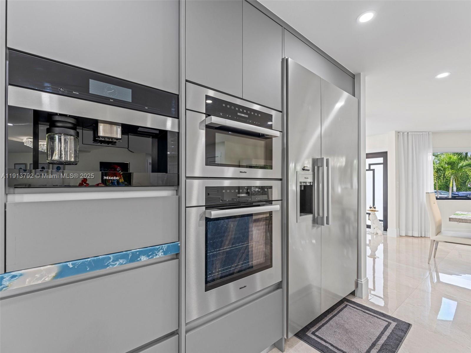 6180 Pine Tree Drive Miami Beach, FL 33140 - Photo 29 of 100 a kitchen with stainless steel appliances a refrigerator and a stove top oven