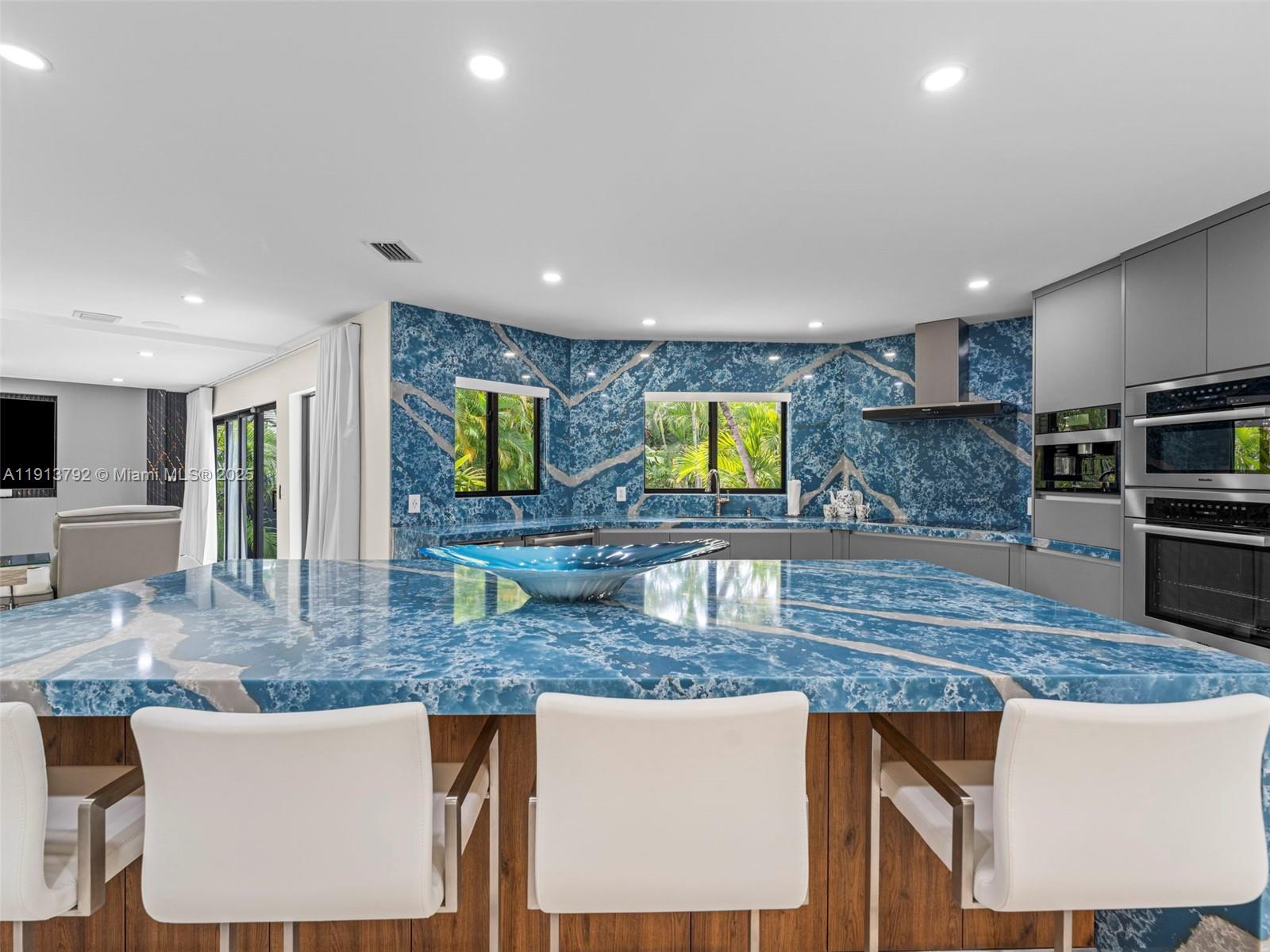6180 Pine Tree Drive Miami Beach, FL 33140 - Photo 32 of 100 a kitchen with kitchen island granite countertop a stove a sink a counter top space cabinets and furniture