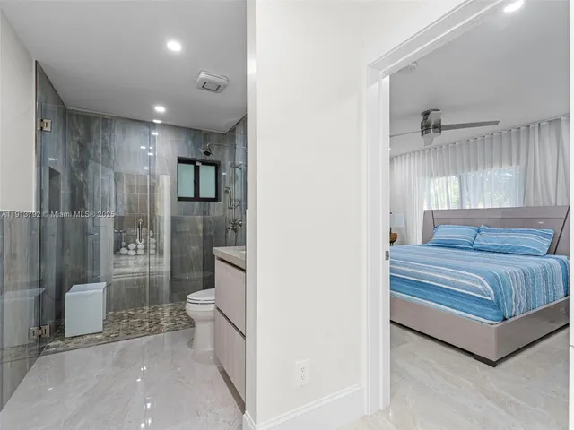 a view of a swimming pool with a lounge chair and palm trees