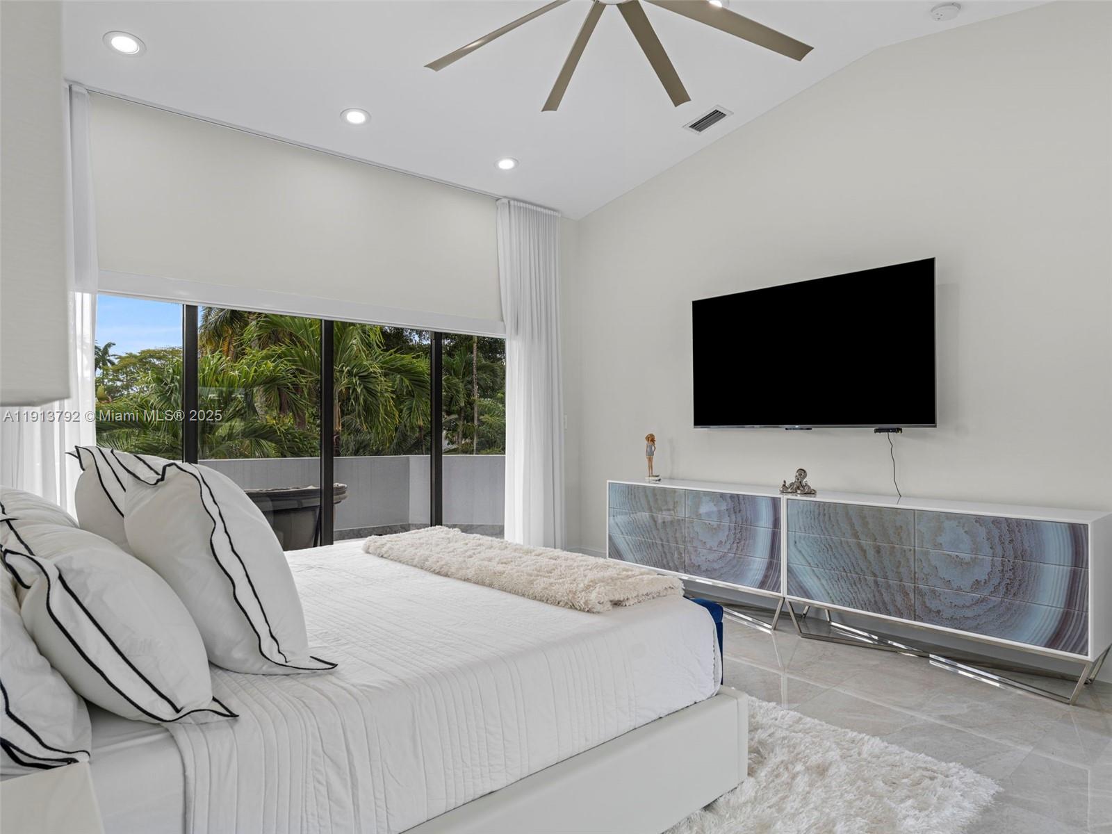 6180 Pine Tree Drive Miami Beach, FL 33140 - Photo 53 of 100 a bedroom with a bed and a flat screen tv