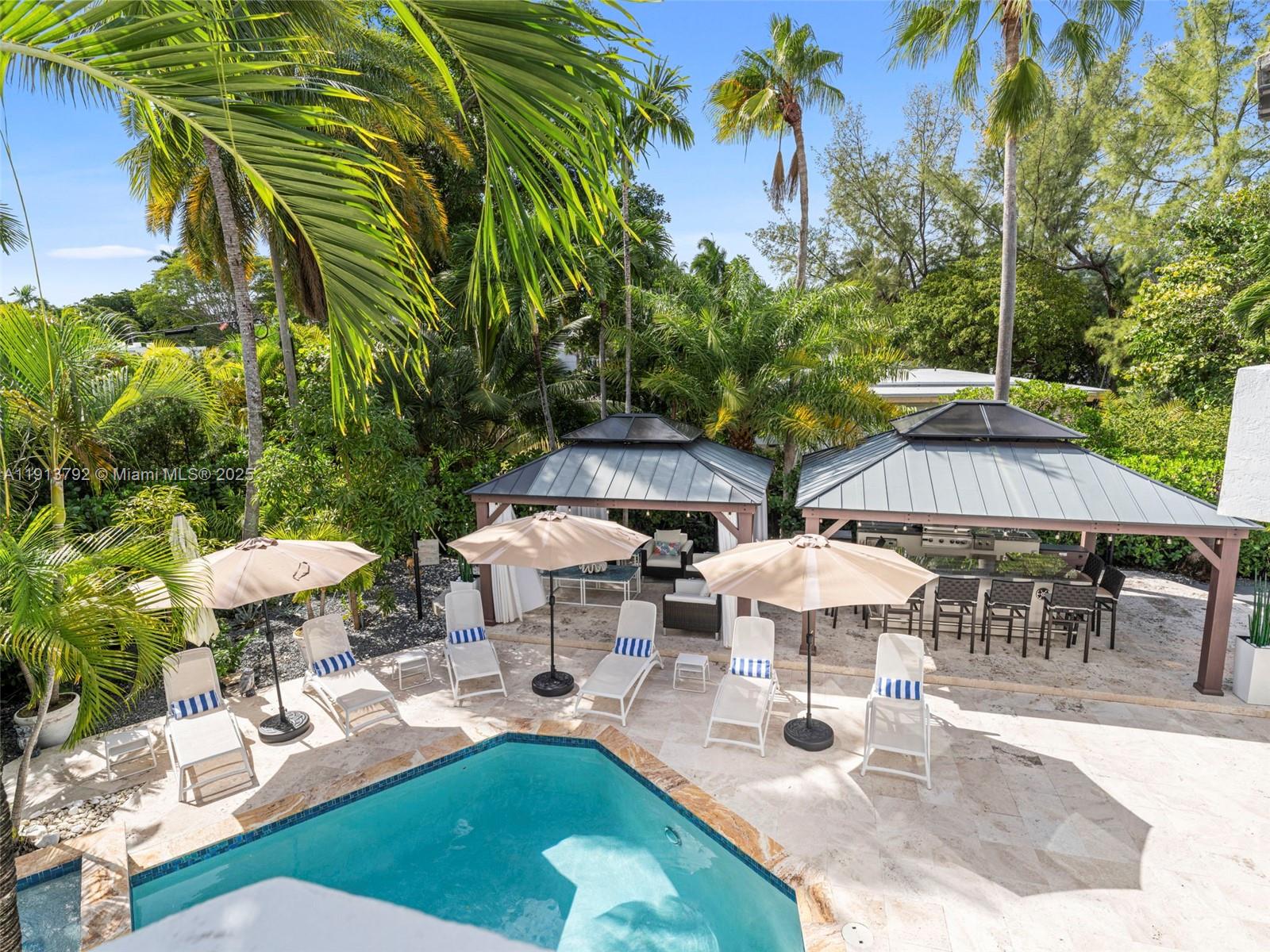 6180 Pine Tree Drive Miami Beach, FL 33140 - Photo 64 of 100 a view of a patio with table and chairs potted plants and large trees