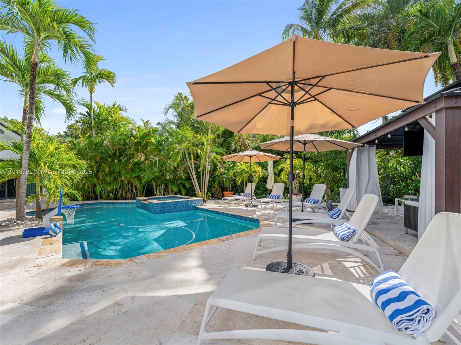 6180 Pine Tree Drive Miami Beach, FL 33140 - Photo 71 of 100 a view of a patio with a table and chairs under an umbrella