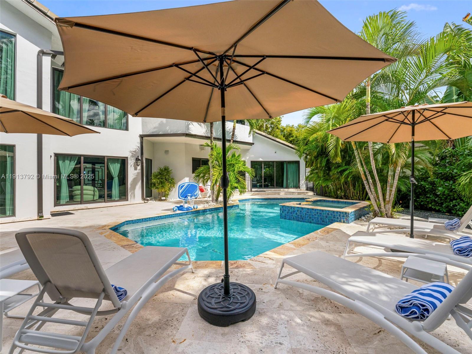 6180 Pine Tree Drive Miami Beach, FL 33140 - Photo 83 of 100 a view of a backyard with a patio and fire pit