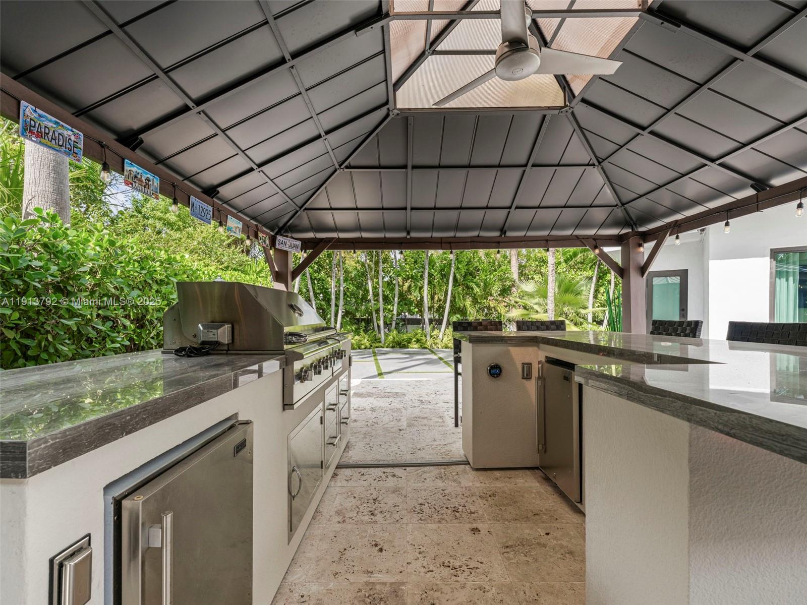 6180 Pine Tree Drive Miami Beach, FL 33140 - Photo 85 of 100 a kitchen with stainless steel appliances granite countertop a sink a stove top oven and garden view