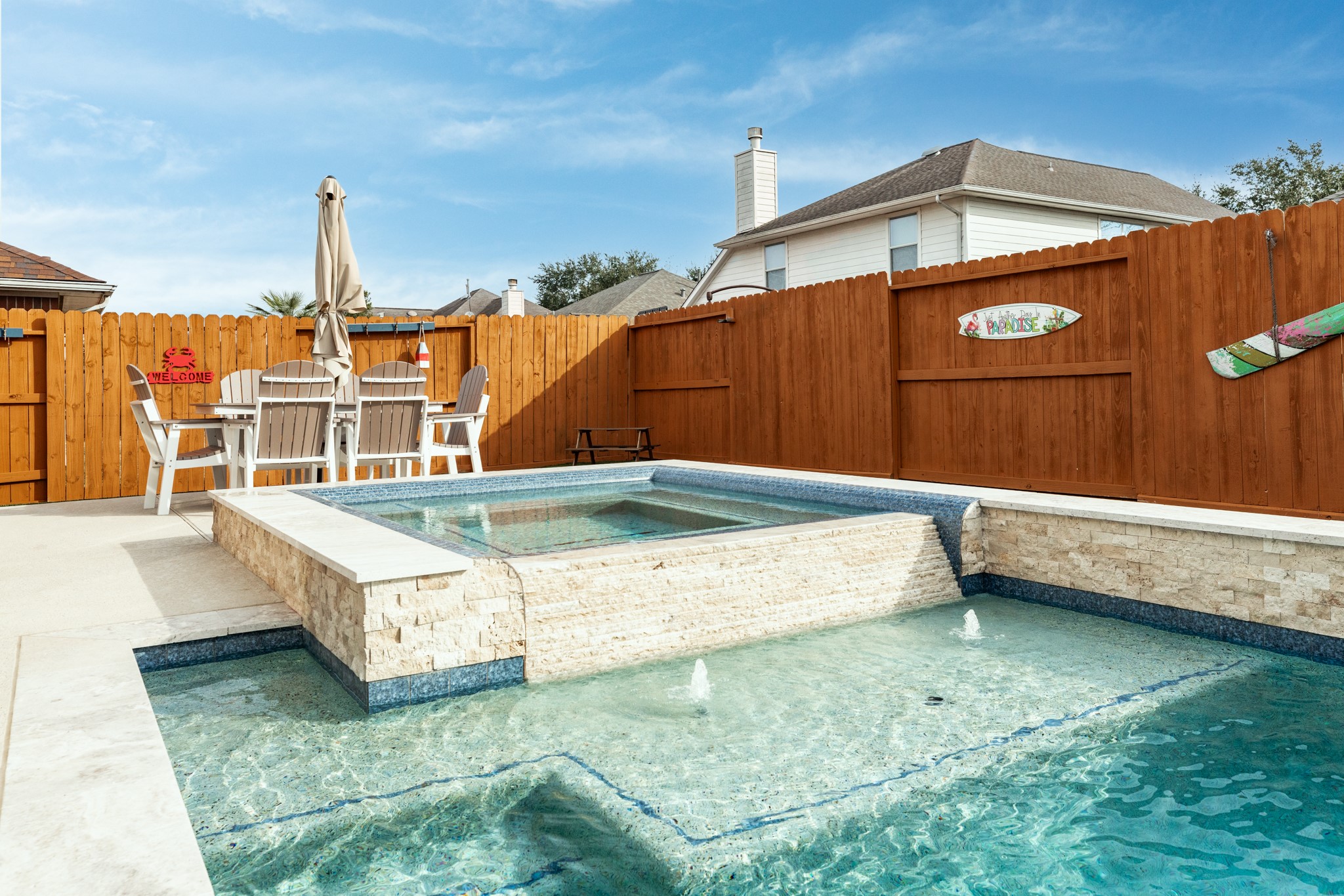 4113 Merlet Drive Pearland, TX 77584 - Photo 28 of 36 Bubblers, tanning ledge, and the hot tub features an infinity look, flowing seamlessly into the pool.