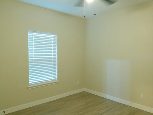 a view of a small space with wooden floor and a window