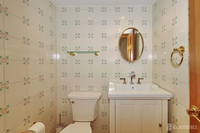 a bathroom with a toilet sink vanity and mirror