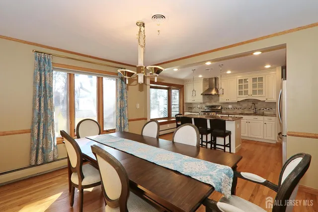 a dining room with furniture a chandelier and wooden floor